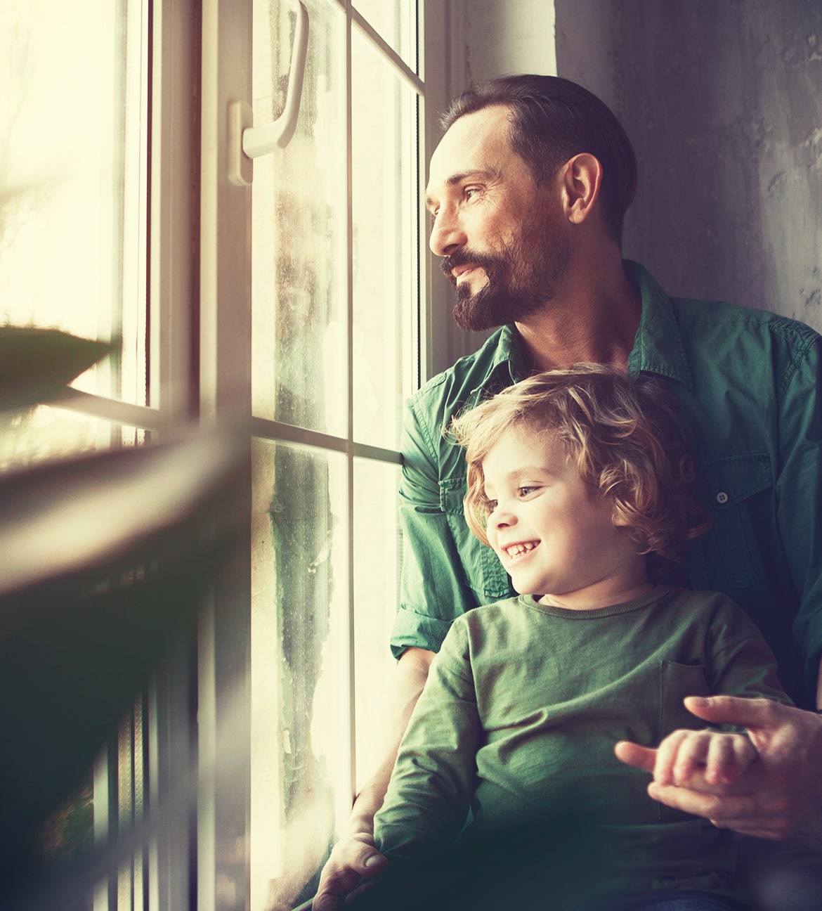 Man and child looking outside the window